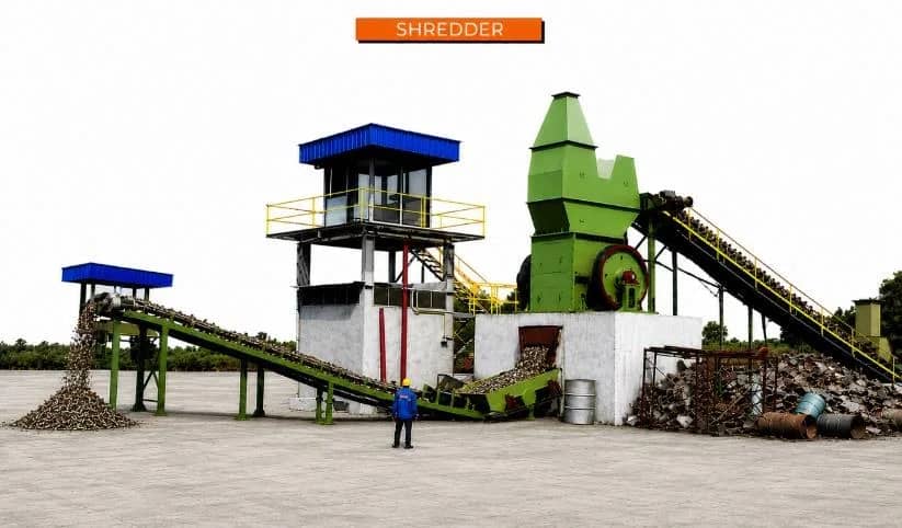 Impact hammer shredder installation with feed conveyor and control cabin at a scrap processing yard